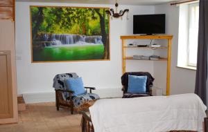 a room with two chairs and a painting on the wall at Maison de 3 chambres avec jardin clos et wifi a Channay sur Lathan in Channay-sur-Lathan