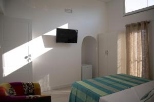 a bedroom with a bed and a tv on the wall at amaMì home in Vietri sul Mare