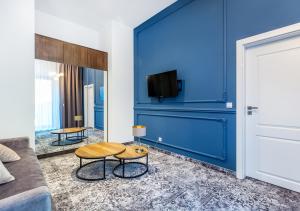a living room with a blue wall with a tv at Aparthotel Cracovia Residence in Krakow