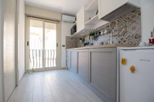 a kitchen with a refrigerator and a tile floor at Casa Elia: Locazione Breve in Noto