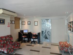 una sala de espera con sillas y un escritorio con ordenador. en Intiotel Piura, en Piura