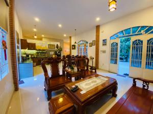 Una sala de estar con sillas y una mesa y una cocina. en Biệt Thự Villa Hai Nam -Vung Tau-G8 Bau Sen 08, en Vung Tau