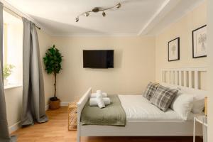 a bedroom with a bed and a tv on the wall at Cosy Dean Village Studio in Edinburgh