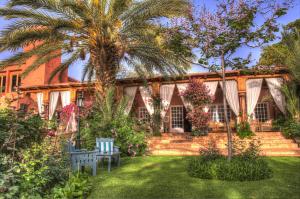 a house with a palm tree and a yard at Domaine de la Roseraie Resort in Ouirgane