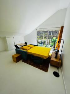 a bedroom with a yellow bed and a table at Appart. avec grande terrasse vue océan in Saint-Gilles les Bains