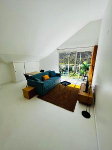 a living room with a blue couch and a window at Appart. avec grande terrasse vue océan in Saint-Gilles les Bains