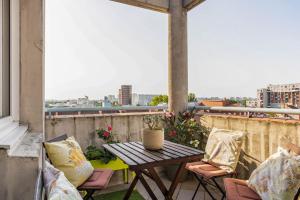 balcón con vistas, mesa de patio y sillas en Appartement à 10 minutes du centre de Paris avec le RER B, en La Courneuve