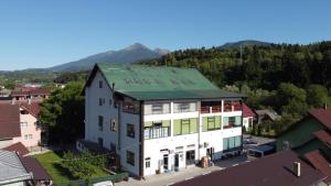 an aerial view of a large white building with a green roof at Pensiunea ATLANTIS in Moisei