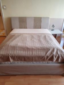 a large bed in a bedroom with a bed frame at M Apartments - Info Park in Budapest