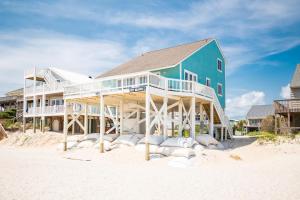 una casa grande en la playa con un edificio en Just Beachy by Oak Island Accommodations, en Oak Island