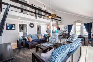 una sala de estar con muebles azules y un loft en Just Beachy by Oak Island Accommodations, en Oak Island