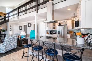 una cocina con encimera y taburetes en Just Beachy by Oak Island Accommodations, en Oak Island