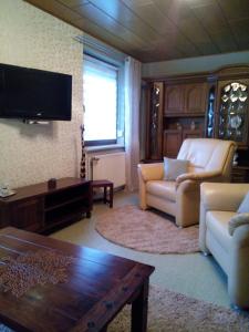 ein Wohnzimmer mit einem Sofa und einem TV in der Unterkunft Ferienwohnung Liselotte in Brotterode
