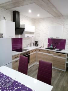 a kitchen with white cabinets and purple accents at Ferienwohnung Liselotte in Brotterode