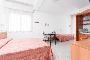 Un dormitorio con una cama y una cocina y una mesa. en Hotel Residence Des Bains, en Cesenatico