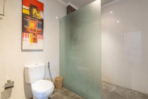 a bathroom with a toilet and a glass shower door at Villa Estella ☆ Seminyak Kuta - Private Pool in Seminyak +22 photos