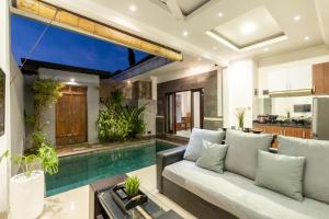 a living room with a couch and a swimming pool at Villa Estella ☆ Seminyak Kuta - Private Pool in Seminyak