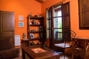 ein Wohnzimmer mit orangefarbenen Wänden und einem Tisch in der Unterkunft Casa Azulete in Bimenes