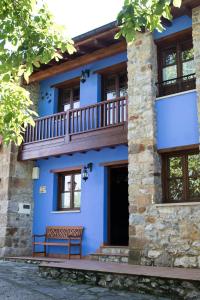 ein blaues Haus mit einem Balkon und einer Bank in der Unterkunft Casa Azulete in Bimenes