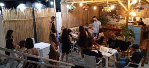 a group of people sitting at tables in a restaurant at Vlora Backpackers Hostel & Bar in Vlorë