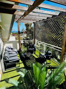 an outdoor patio with lounge chairs and palm trees at Appart. avec grande terrasse vue océan in Saint-Gilles les Bains