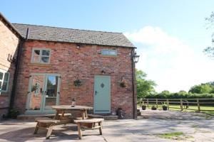 a brick building with a picnic table in front of it at The Hoglets in Goostrey