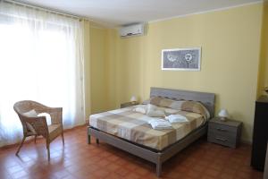 マンドゥーリアにあるB&B Abitazione Sandraのベッドルーム1室(ベッド1台、椅子、窓付)