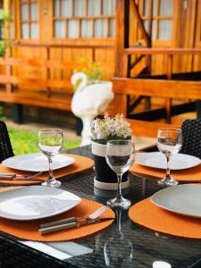 una mesa con platos y copas de vino. en CHALET TARAPOTO, en Tarapoto