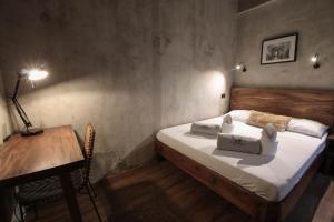 a bedroom with a bed and a table and a desk at Shorebreak Hostel San Juan La Union in san juan la union