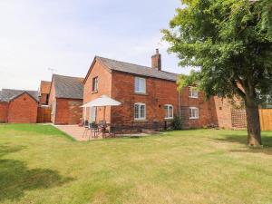 a brick house with a table and chairs in a yard at Hill Farm in Nantwich