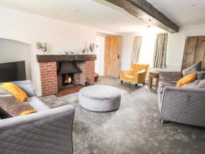 a living room with two couches and a fireplace at Hill Farm in Nantwich