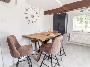 a dining room with a wooden table and chairs at Hill Farm in Nantwich