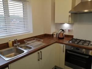 a kitchen with a sink and a counter top at StayNEC LAMPREY- Lux Apartment - Birmingham - For Company, Contractor & Leisure Stays NEC, HS2, JLR, Airport in Kingshurst