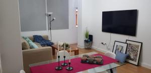 een woonkamer met een tafel en een televisie bij Apartamento cerca de la Playa de Las Canteras in Las Palmas de Gran Canaria