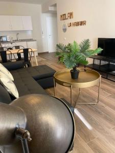 ein Wohnzimmer mit einer Couch und einem Tisch mit einer Pflanze in der Unterkunft Apartamentos San Miguel in Torremolinos