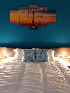 a bedroom with a white bed with a view of the eiffel tower at A Ground Floor Maisonette - Mellieha Bay in Is-Sellum
