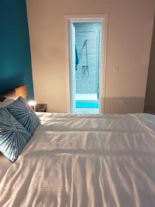 a white bed with a pillow and a window at A Ground Floor Maisonette - Mellieha Bay in Is-Sellum