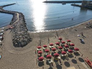 an aerial view of a beach with red umbrellas at MIIO HOTEL in San Vincenzo