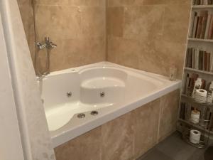 a white bath tub in a bathroom at A Room in the City - West in Edinburgh +30 photos