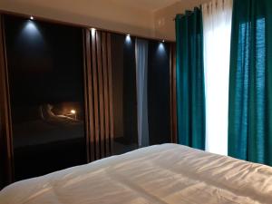 a bedroom with a bed and a window with curtains at A Ground Floor Maisonette - Mellieha Bay in Is-Sellum
