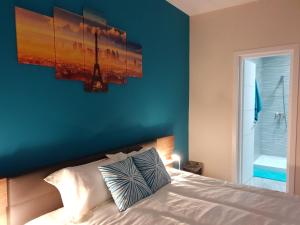 a bedroom with a bed with a blue wall at A Ground Floor Maisonette - Mellieha Bay in Is-Sellum