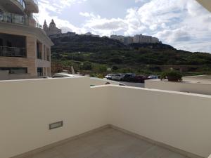 a balcony with a view of a parking lot at A Ground Floor Maisonette - Mellieha Bay in Is-Sellum