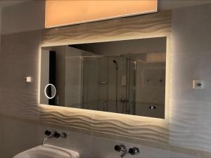 a bathroom mirror with a sink and a shower at Seeblick SMART Hotel Rössli in Murg +109 photos