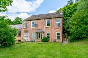 une ancienne maison en briques avec une grande cour dans l'établissement Shuttle Apartment, à Northallerton