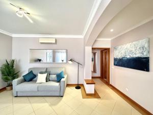 una sala de estar con sofá y una pintura en la pared en Victoria I - Vasco da Gama by HD PROPERTIES, en Vilamoura