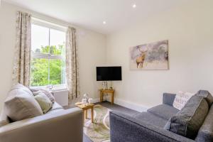 a living room with two couches and a tv at Shuttle Apartment in Northallerton