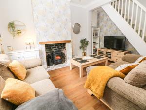 sala de estar con sofá y chimenea en Appletree Cottage, en Chesterfield
