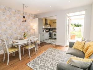 a kitchen and living room with a table and chairs at Appletree Cottage in Chesterfield
