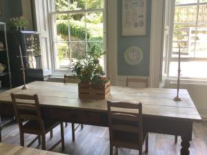 a dining room table with chairs and a plant on it at A Room in the City - West in Edinburgh