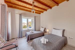 a bedroom with two beds and a window at TAKIS GUESTHOUSE-Orneda-HERMOUPOLIS in Ermoupoli
